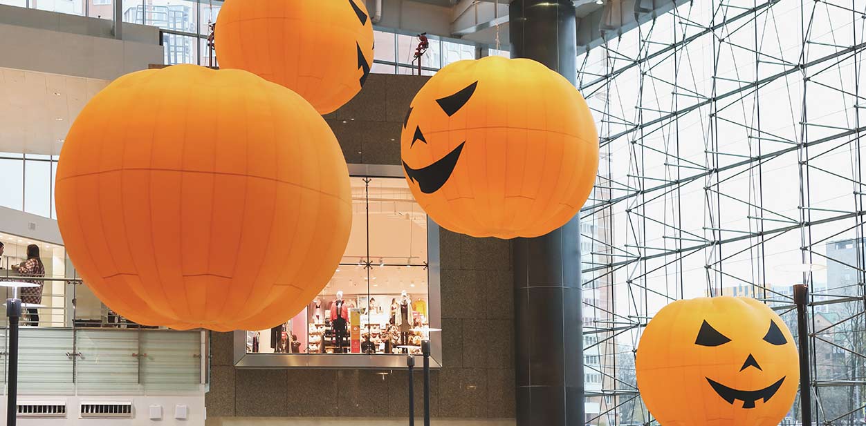 Custom Halloween retail signs in the form of large hanging pumpkins