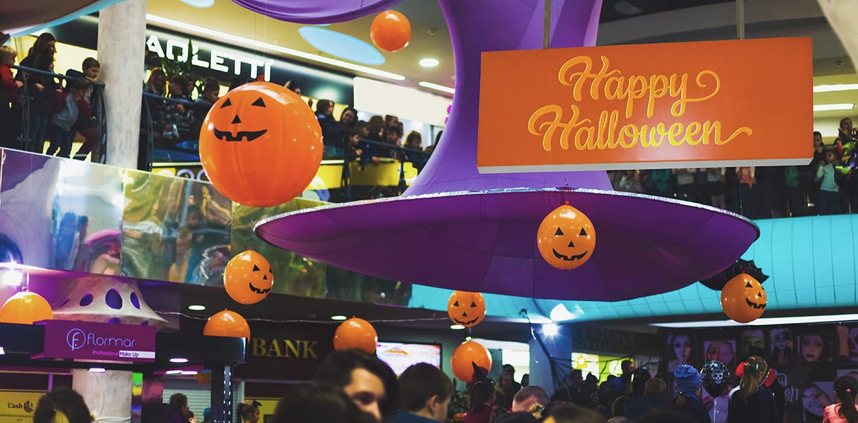 Hanging Halloween store signage and decorative pumpkins in orange