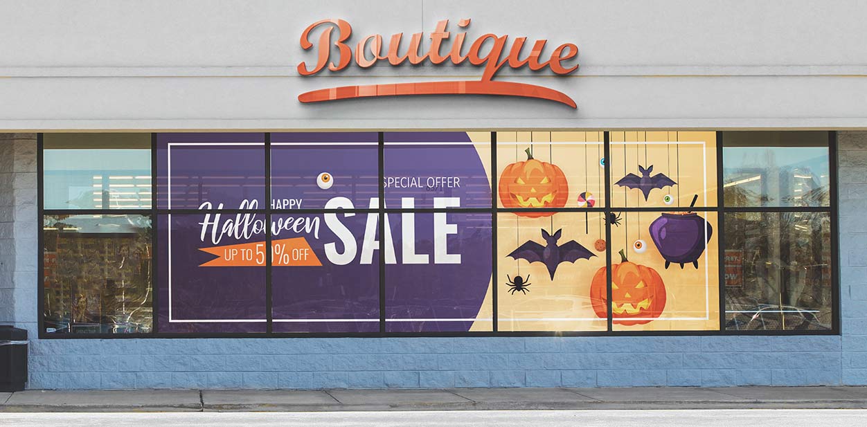 Large Halloween sign with holiday themed graphics displayed on the window