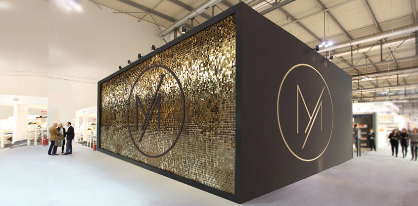 Golden shimmer wall with a brand logo for trade show booth design