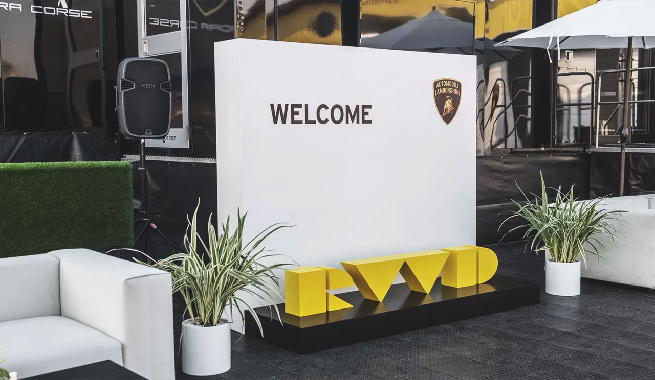Exterior white and yellow event design solution with three-dimensional text featuring 'WELCOME' with logo design
