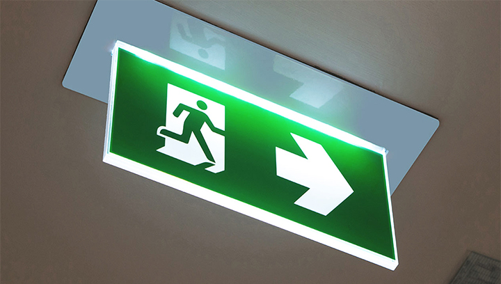 Illuminated directional exit sign in green made of acrylic
