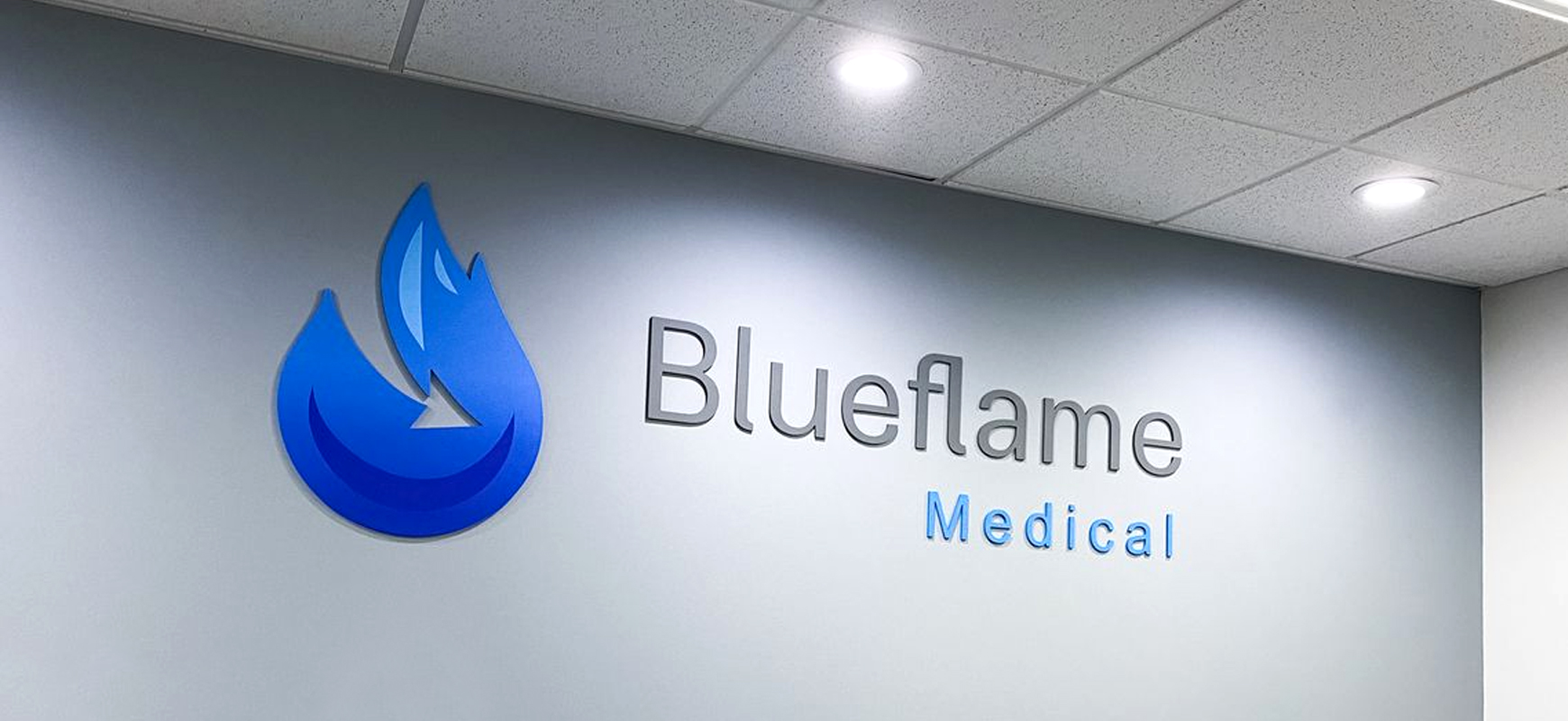 Blueflame indoor medical office signs displaying the brand name and logo