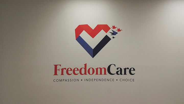 Freedom Care medical office wall sign displaying the brand name and logo