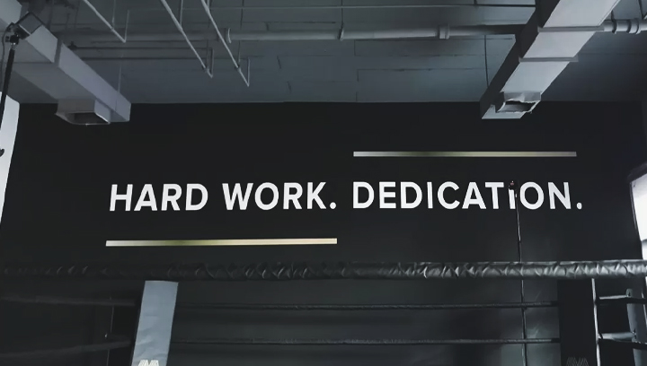 Motivational gym sign displaying the phrases Hard Work and Dedication