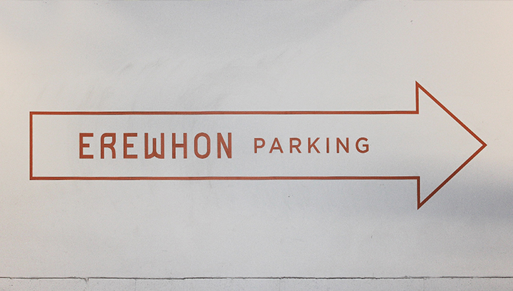 Wall wayfinding sign pointing at the parking made of opaque vinyl