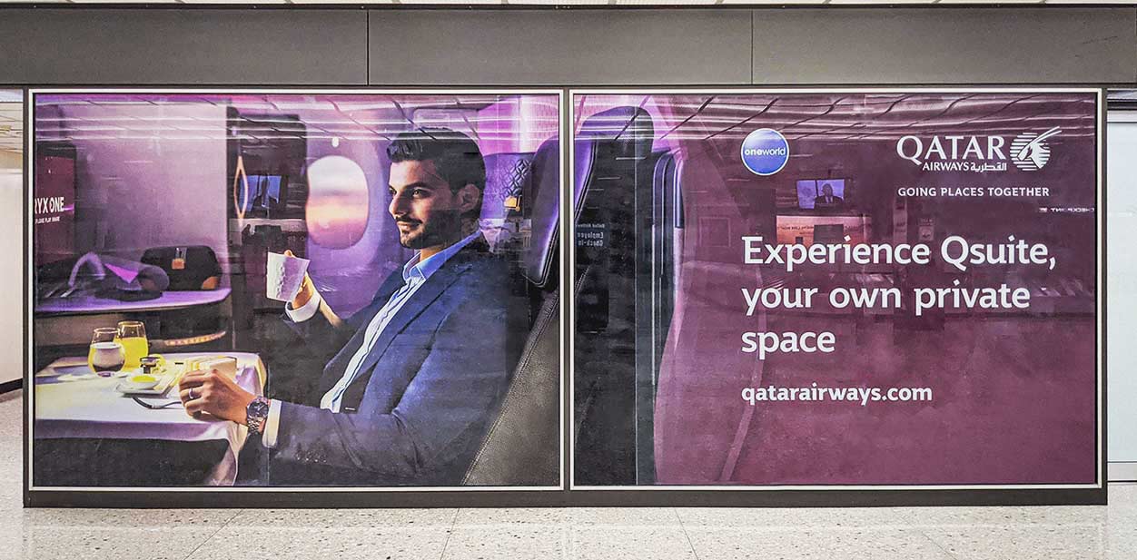 Qatar Airways wall design depicting a satisfied customer’s face with company's logo and motto