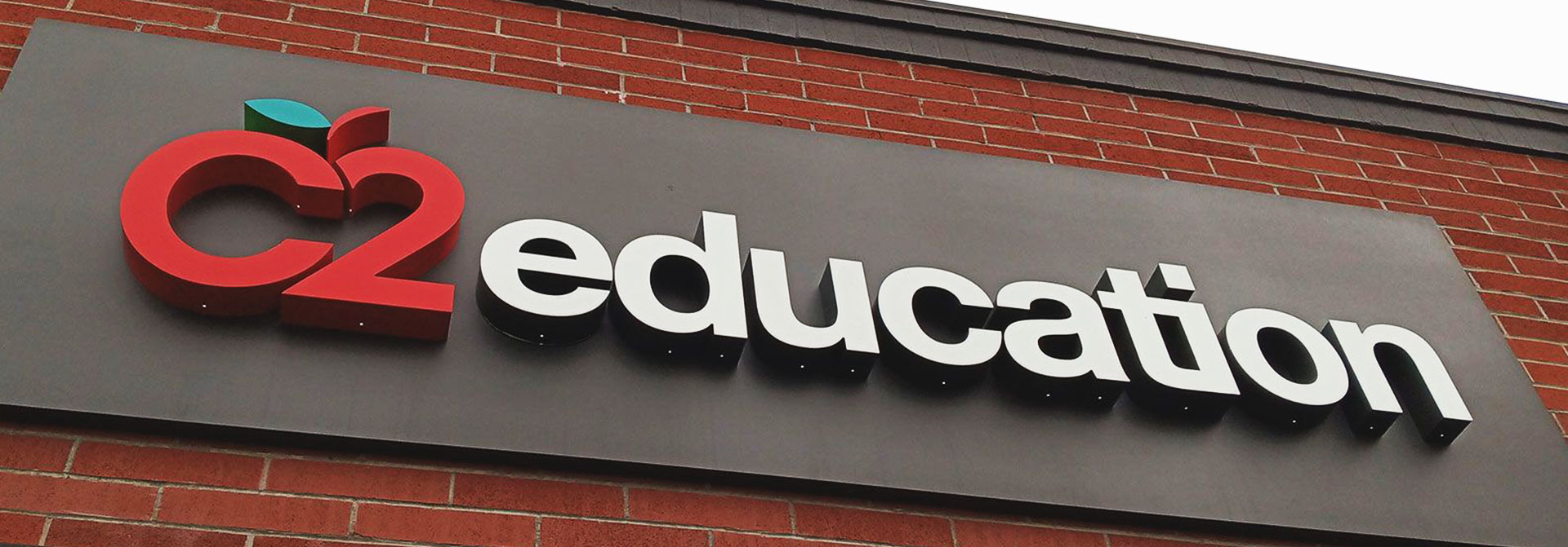 Storefront campus signage design featuring logo in red and a text 'education' in white