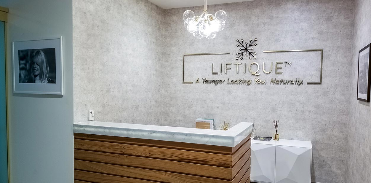 Liftique office reception design solution wall-mounted with the company's name and slogan