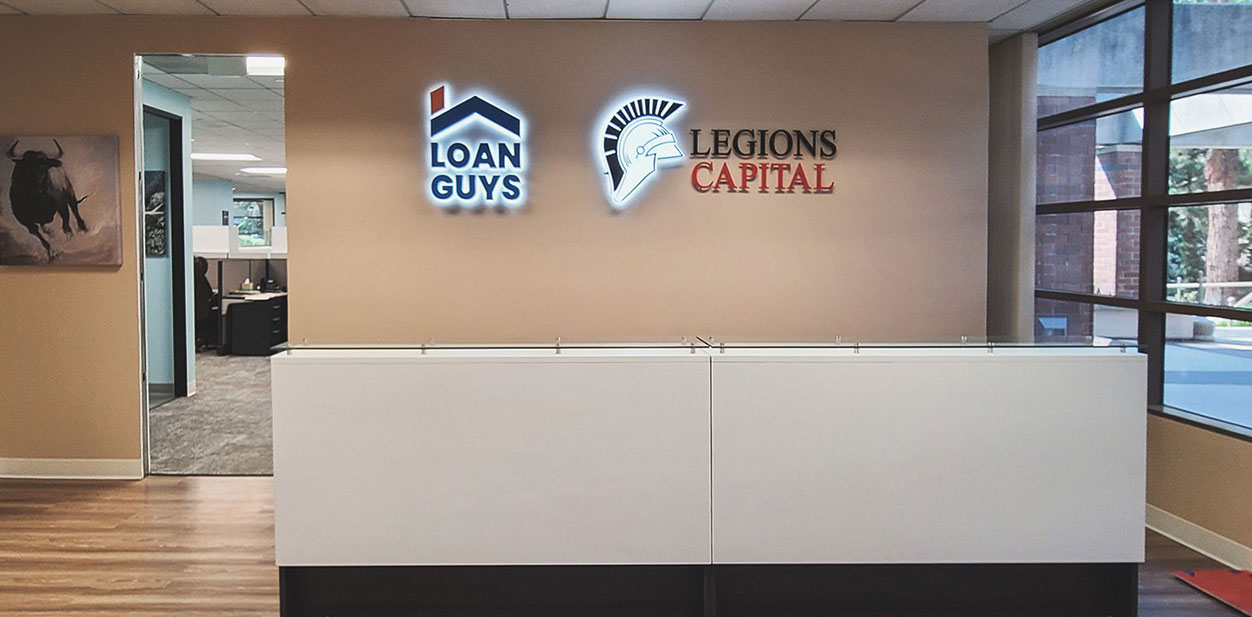  Illuminated office lobby design with texts 'Loan Guys' and 'Legions Capital'