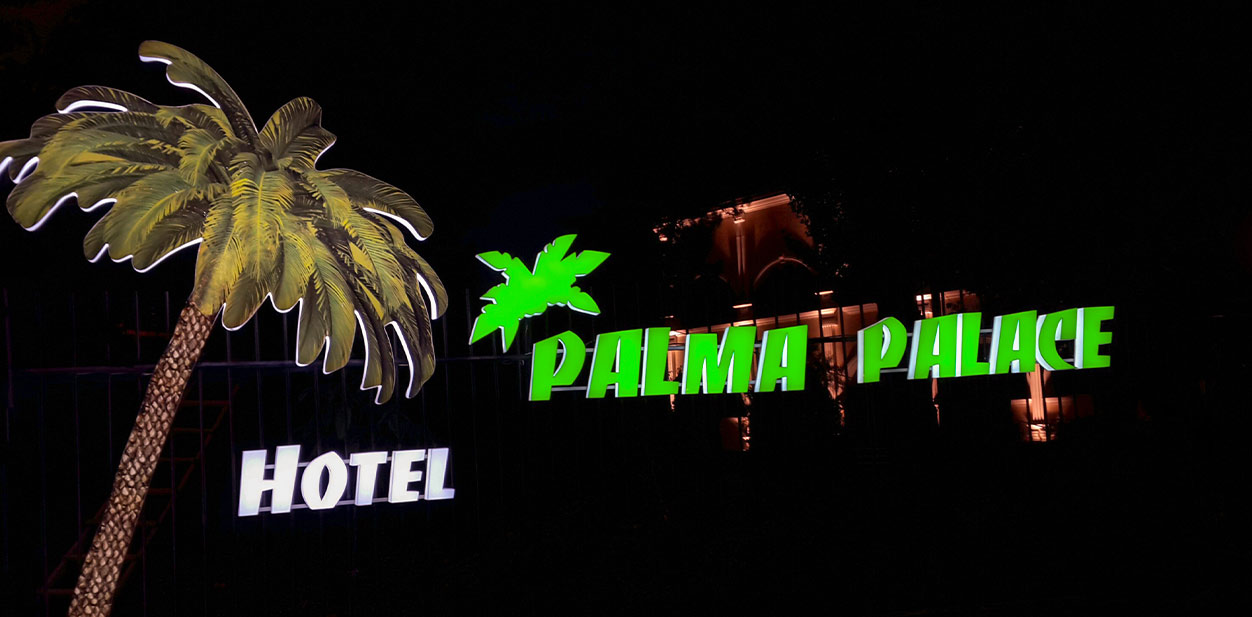 Hotel branding design for Palma Palace Hotel with illuminated signs featuring the hotel's logo in the shape of palm