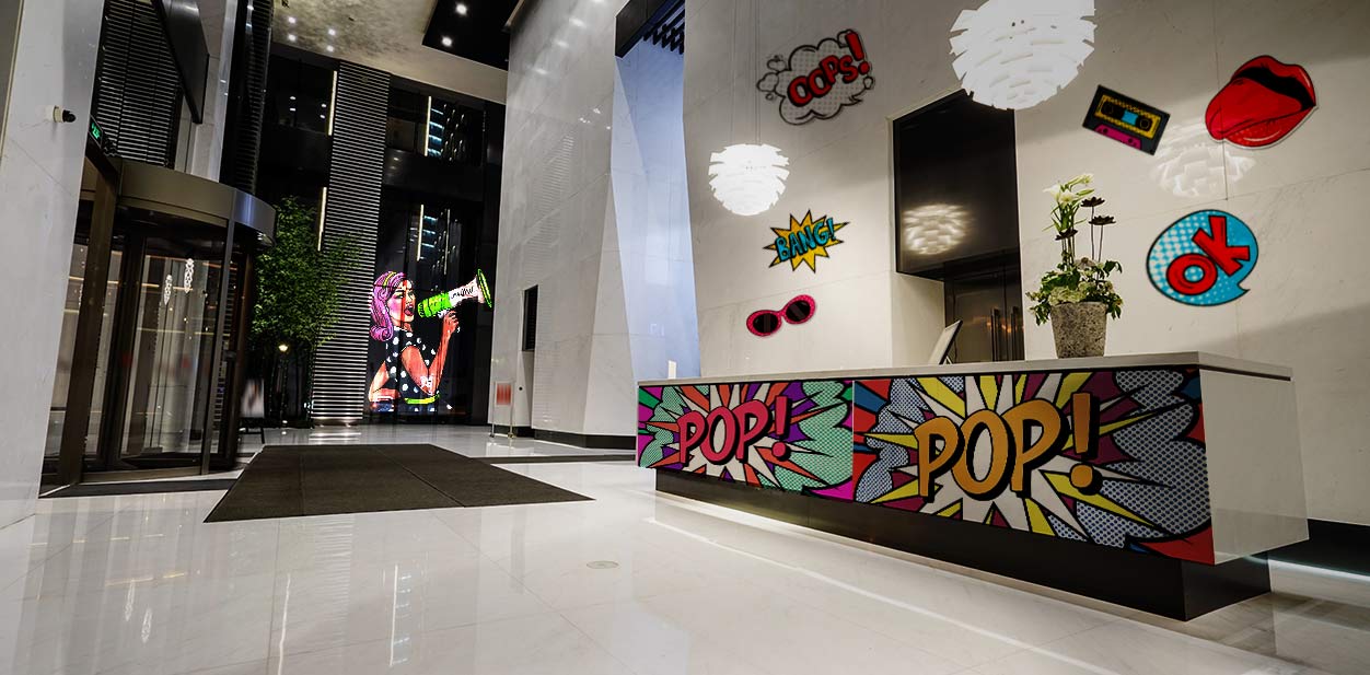 Pop-art office lobby design with thematic wraps on the walls and doors.