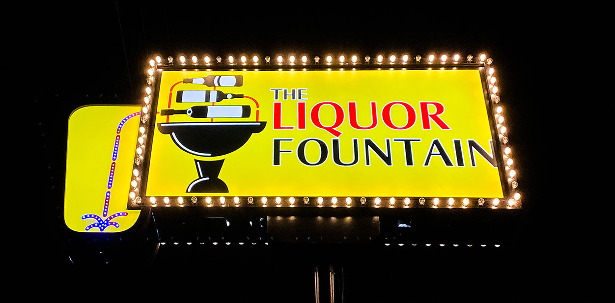 The Liquor Fountain illuminated bar branding design with wine bottles
