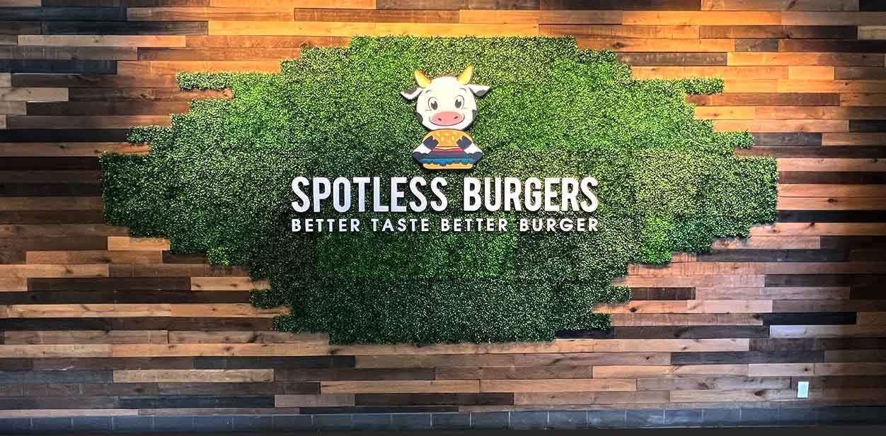 Spotless Burgers restaurant branding design with wooden and grass elements
