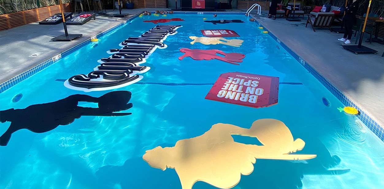 Event branding design with floating letters and cut-out shapes in the pool