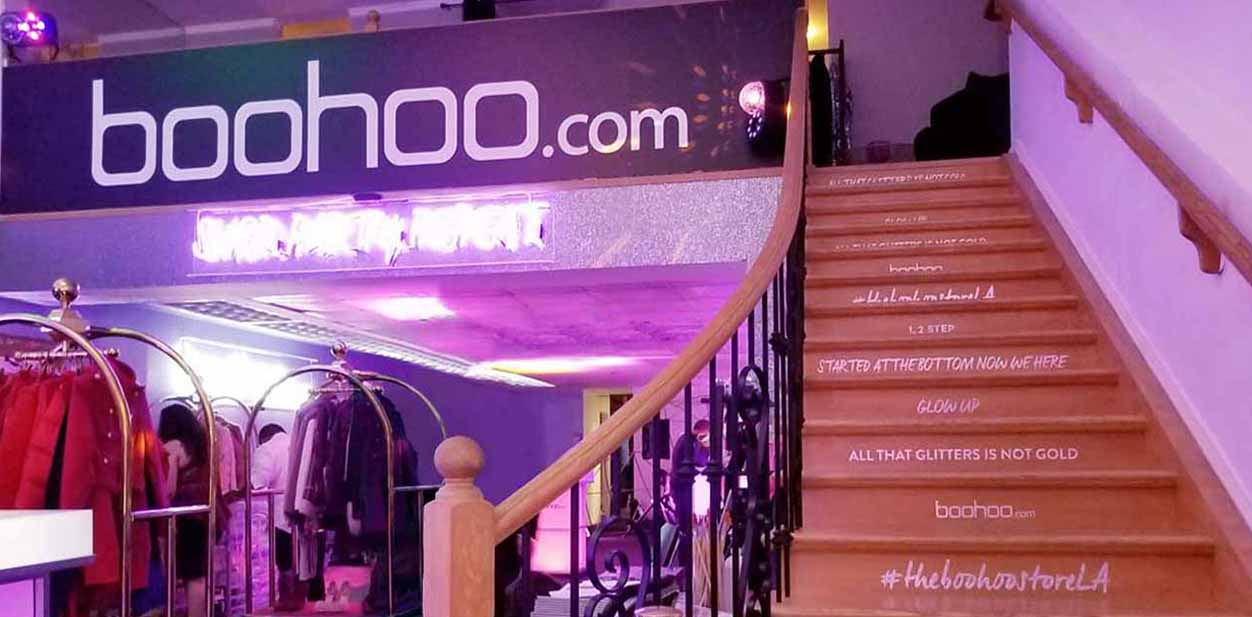 Boohoo fashion event branding designs displayed on stairs and in the venue