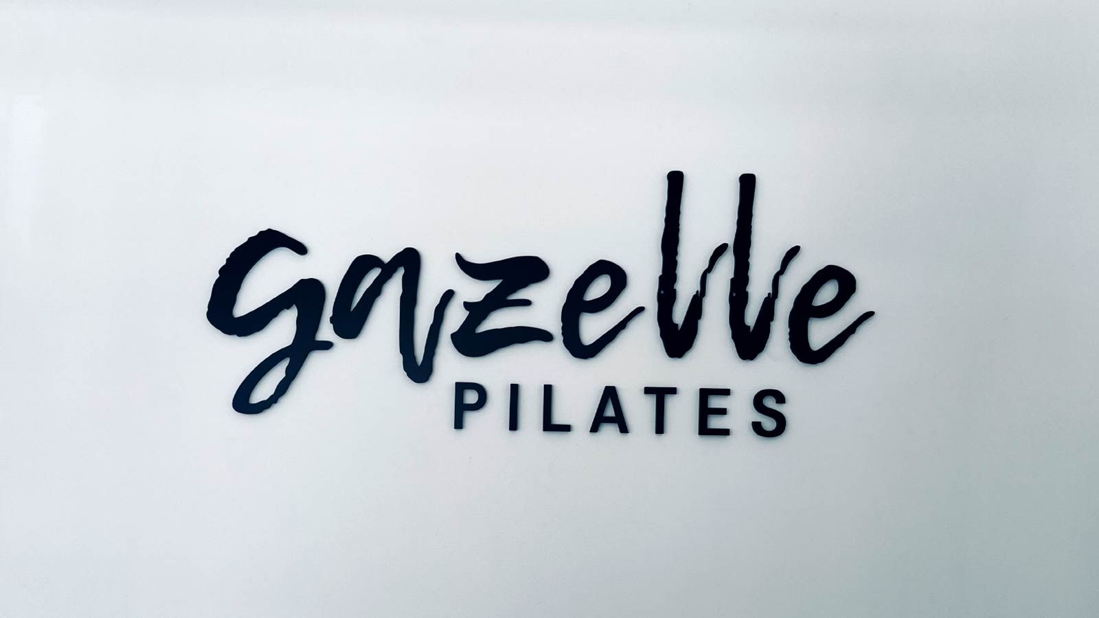 Gazelle Pilates custom lobby sign mounted to the wall