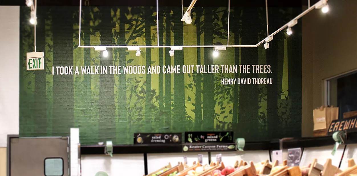 Large grocery store branding display with forest-themed graphics