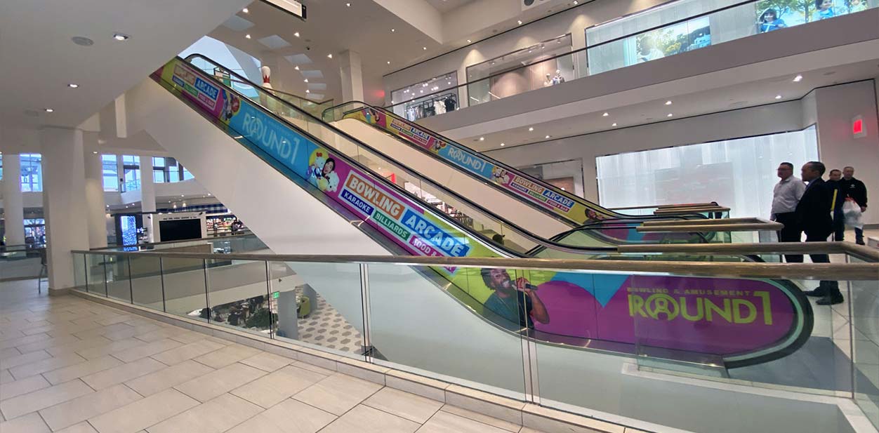 Colorful in store branding wraps attached to the escalator