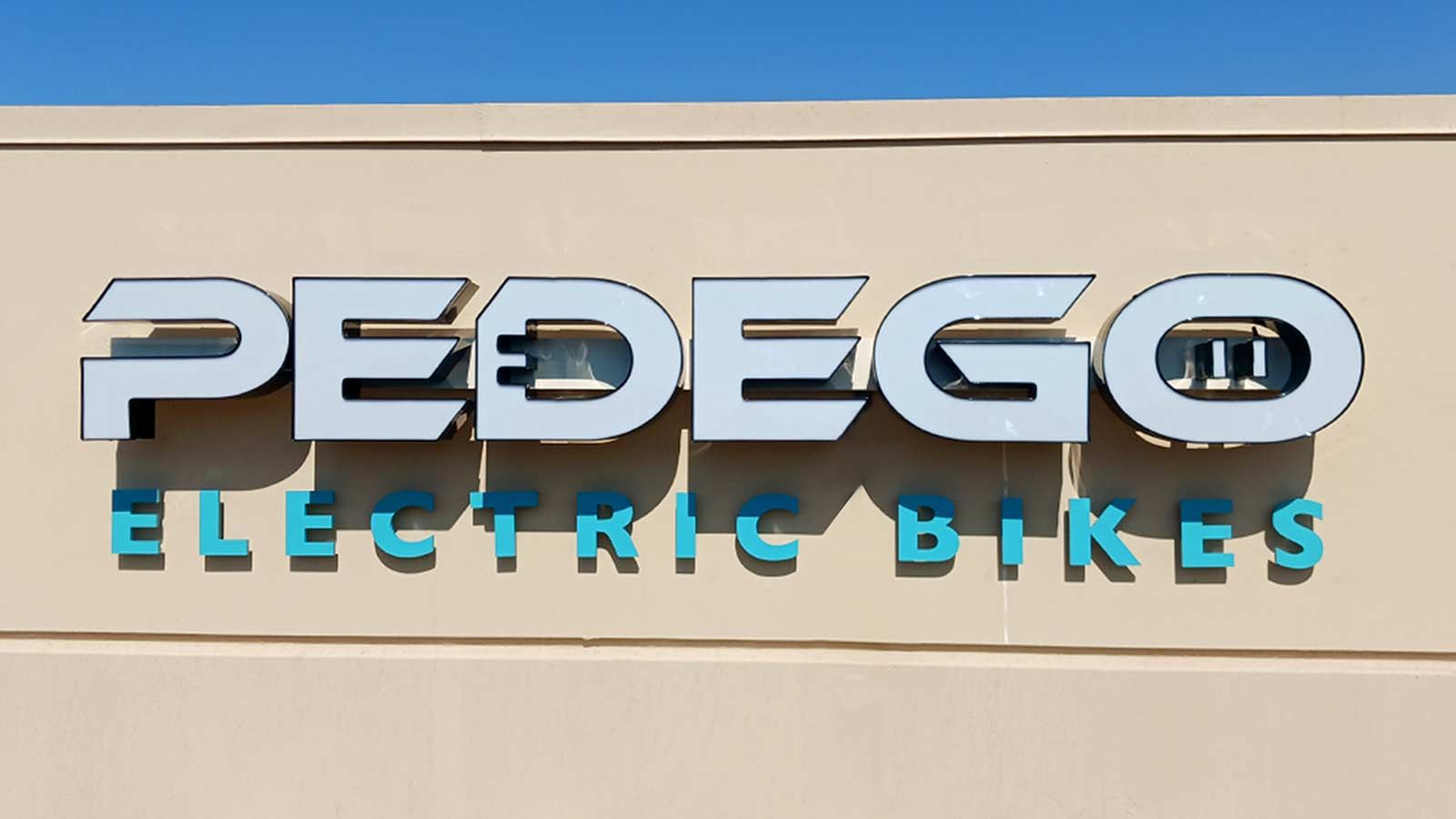 Pedego Electric Bikes signs attached to the building wall