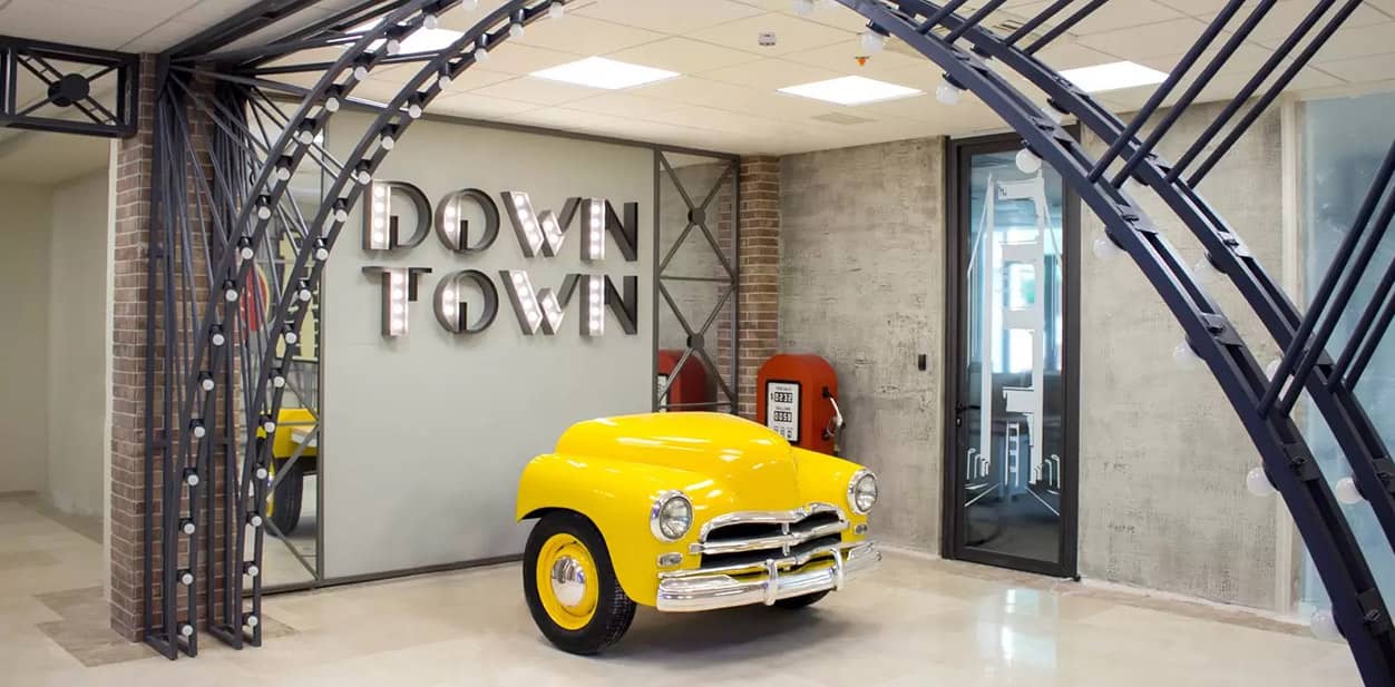 Architectural feature wall with a yellow car structure, decorative mirrors and retro letters