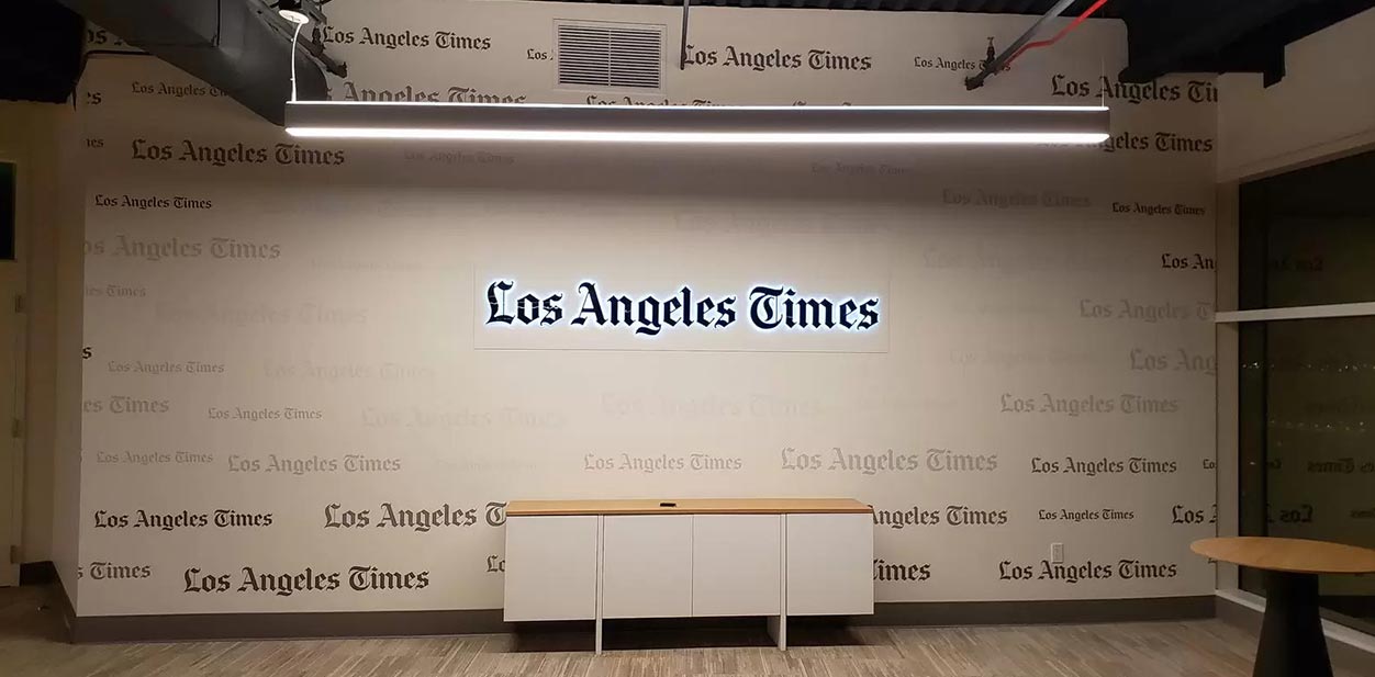 Los Angeles Times feature wall with lighting displaying the brand name multiple times
