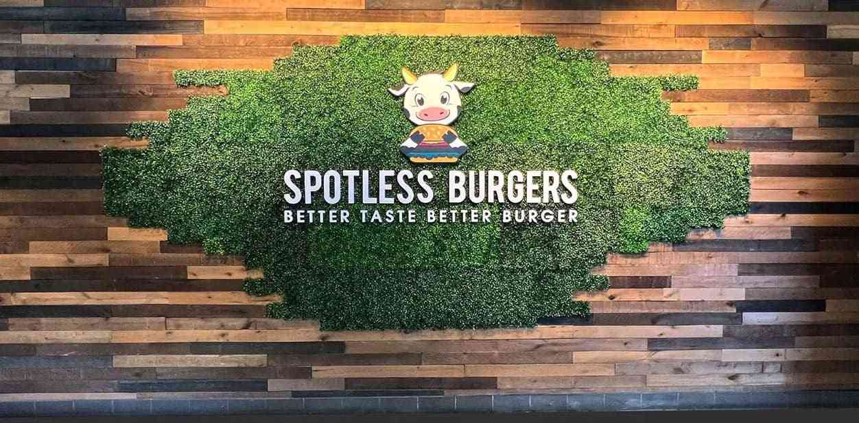 Spotless Burgers custom feature wall with grass and wood background for restaurant branding