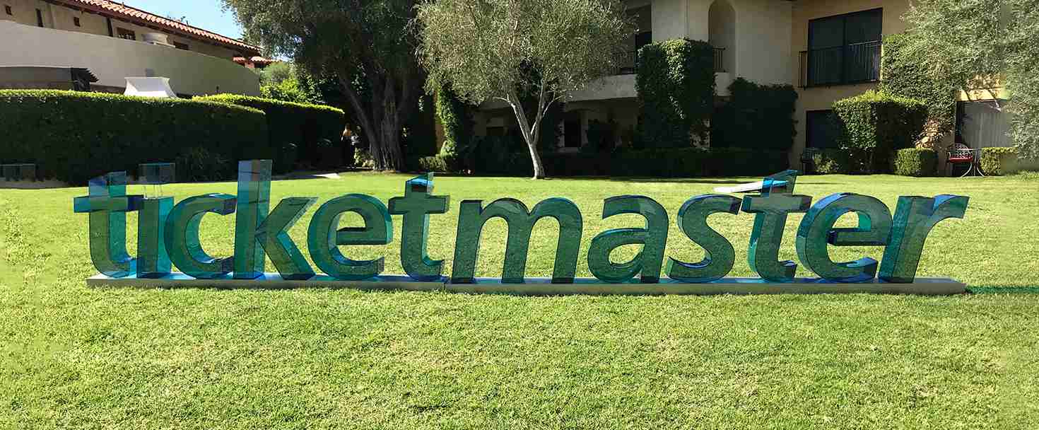 Ticketmaster 3d acrylic letters in green freestanding outdoors and displaying the brand name