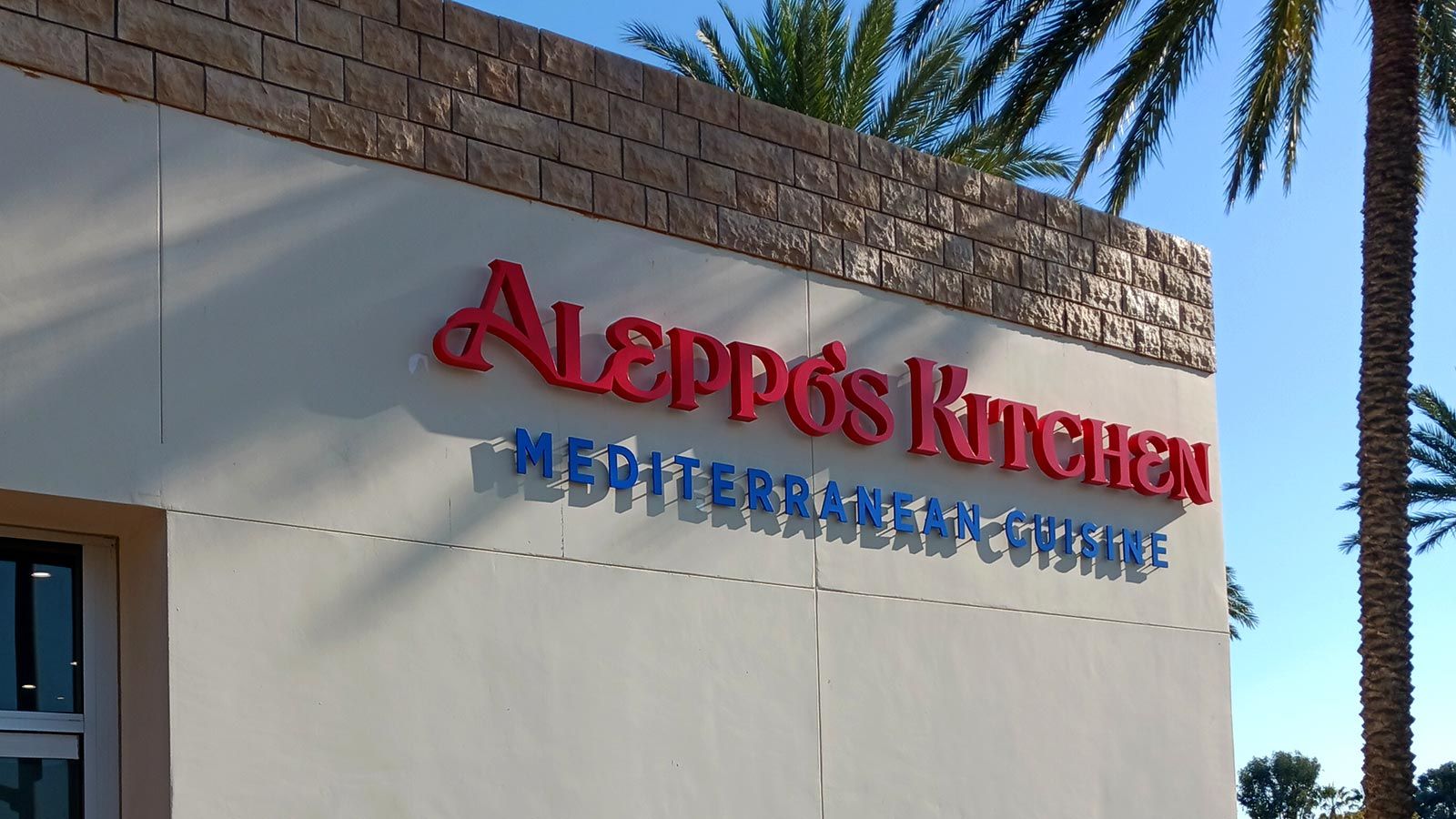 Aleppo's Kitchen light up sign installed outdoors