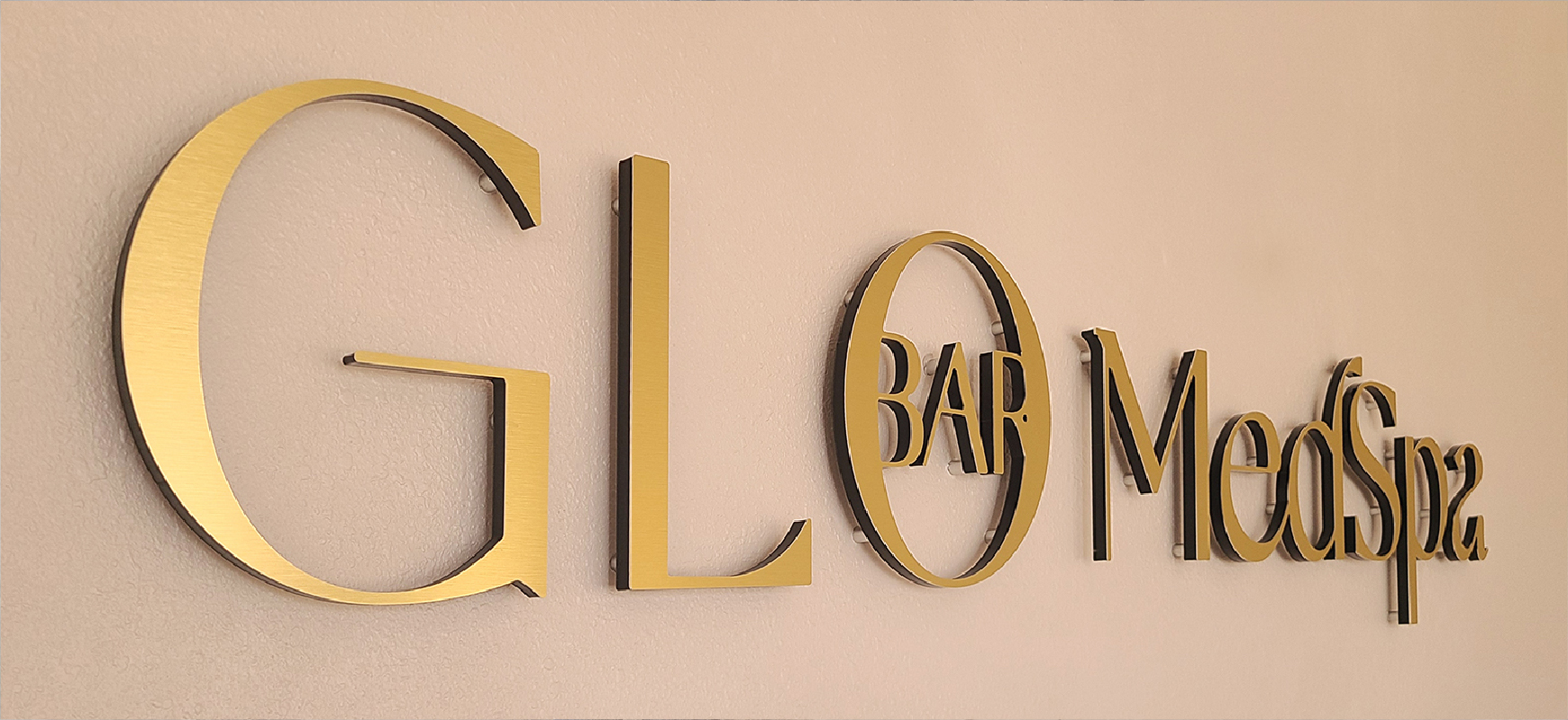Glo Bar Med Spa letter signage with gold finish made of brushed aluminum for interior branding