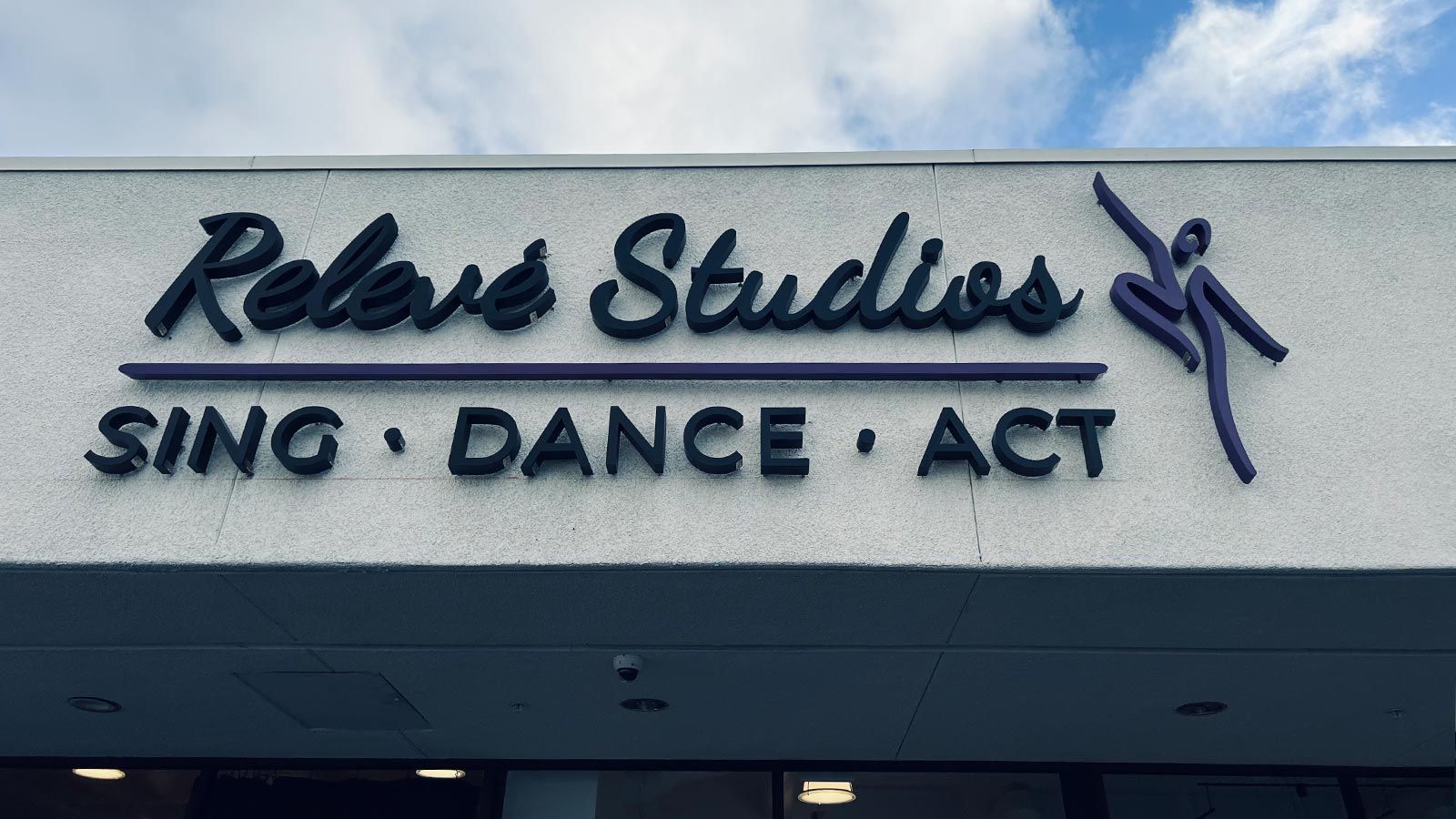 Relevé Studios backlit letters attached above the entrance