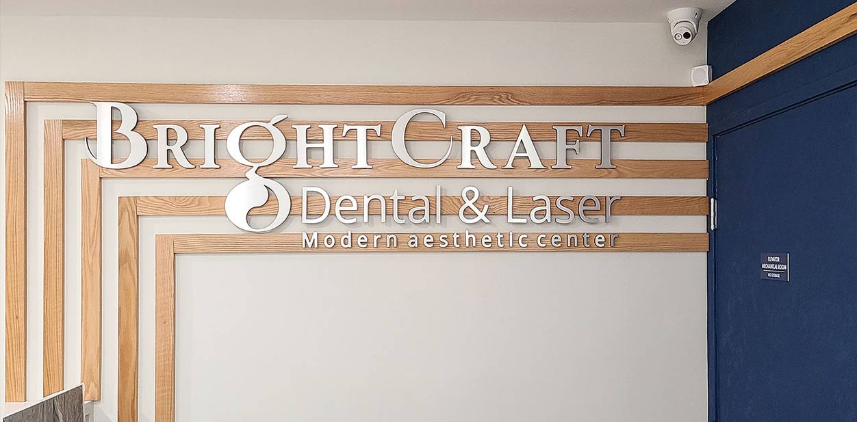 Bright Craft office accent wall displaying the aluminum brand name on wooden panels