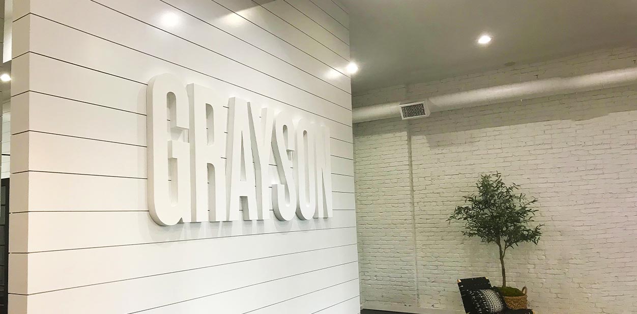 Grayson accent wall design in a white minimalistic style displaying the brand name letters