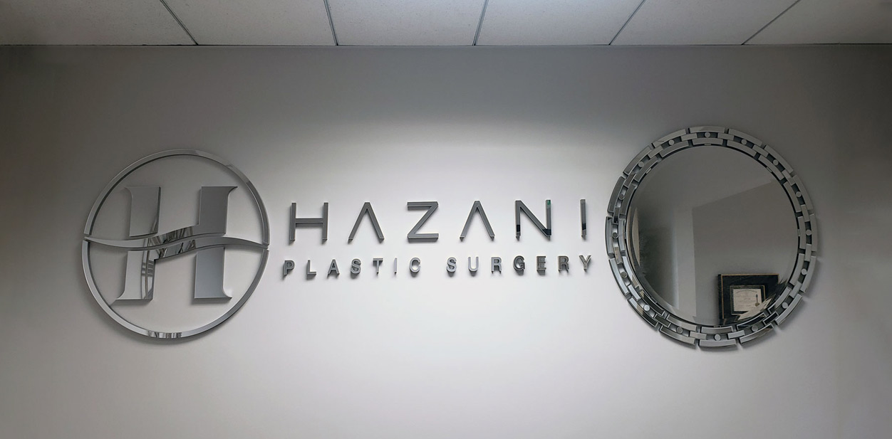 Hazani accent wall design with the aluminum brand name, logo and a decorative mirror