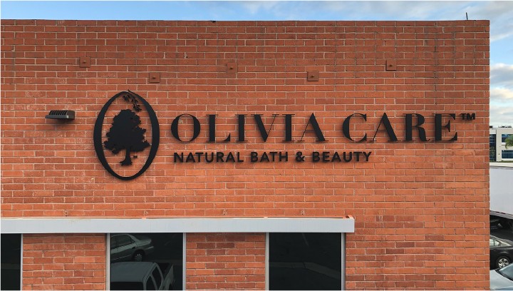 Olivia Care letter signage in black spelling the brand name and motto made of acrylic