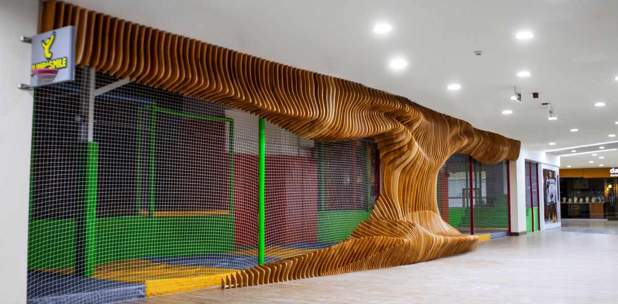 Architectural accent wall with wood design in the shape of a wave in shopping mall