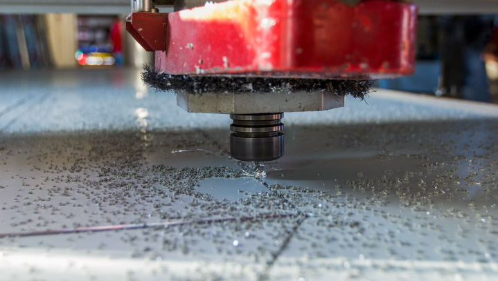 High-precision CNC cutting on a sheet of aluminum for branding purposes