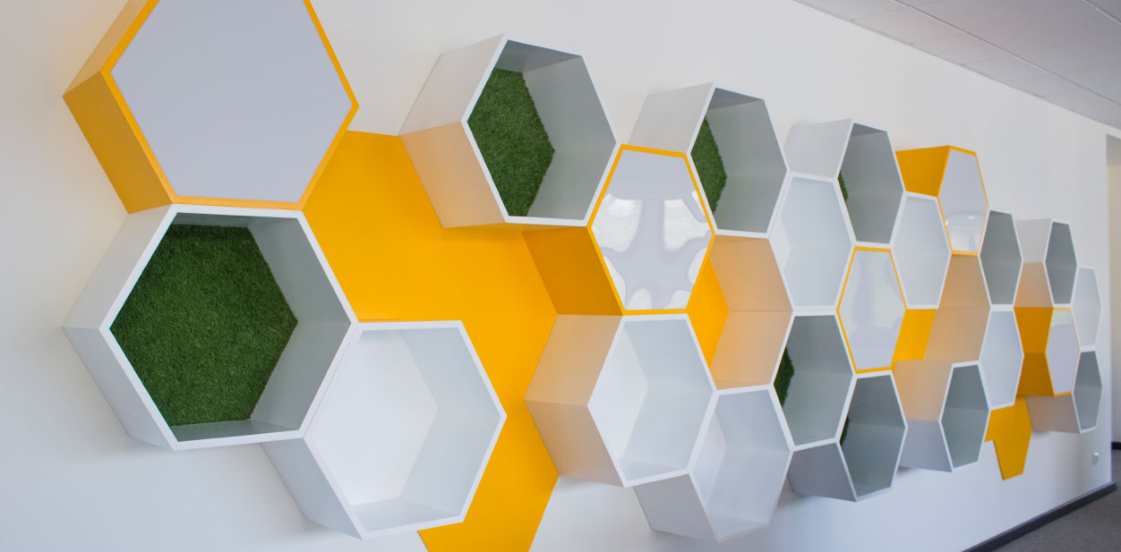 Geometric wood accent wall with a colorful combination of grass, white acrylic and yellow hues