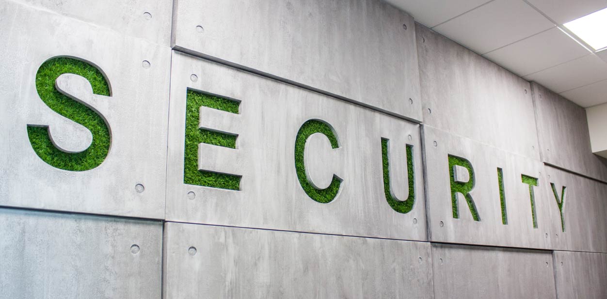 Eco-friendly accent wall with wood design displaying the word ''SECURITY' with grass decor