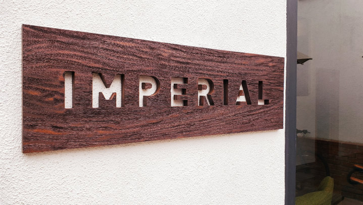 Imperial CNC cutting display with cut-out letters made of wood for outdoor branding