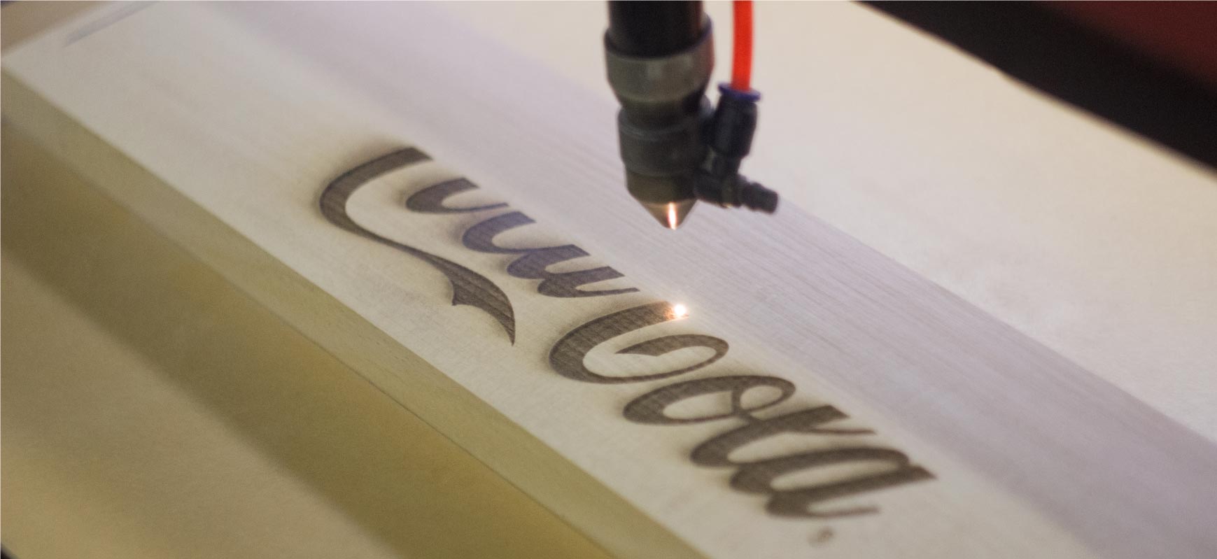 Coca-Cola laser engraving process on a wooden plank using an accurate and focused laser beam