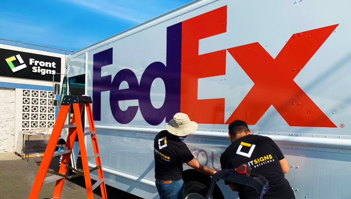 FedEx adhesive vinyl sign installation on a van for in-motion branding