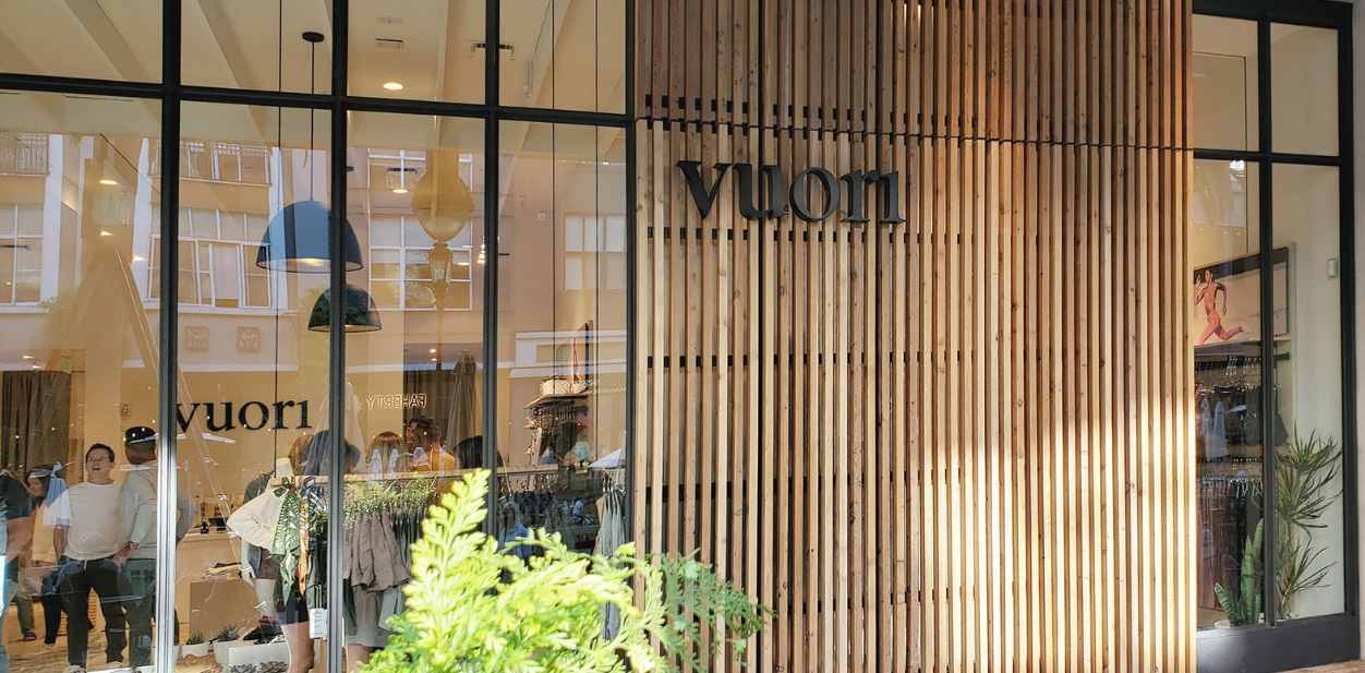 Vuori wood design accent wall with vertical slats and black brand name display