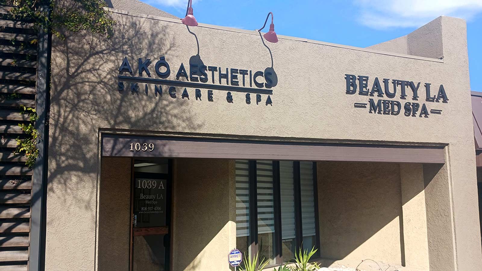 AKO Aesthetics PVC sign attached to the storefront