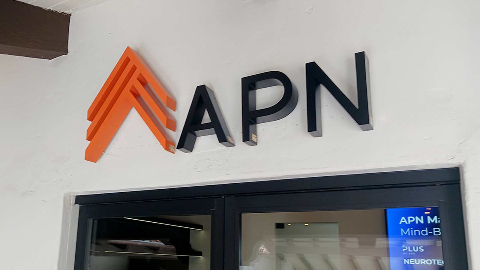 APN Capital light up sign mounted on the wall