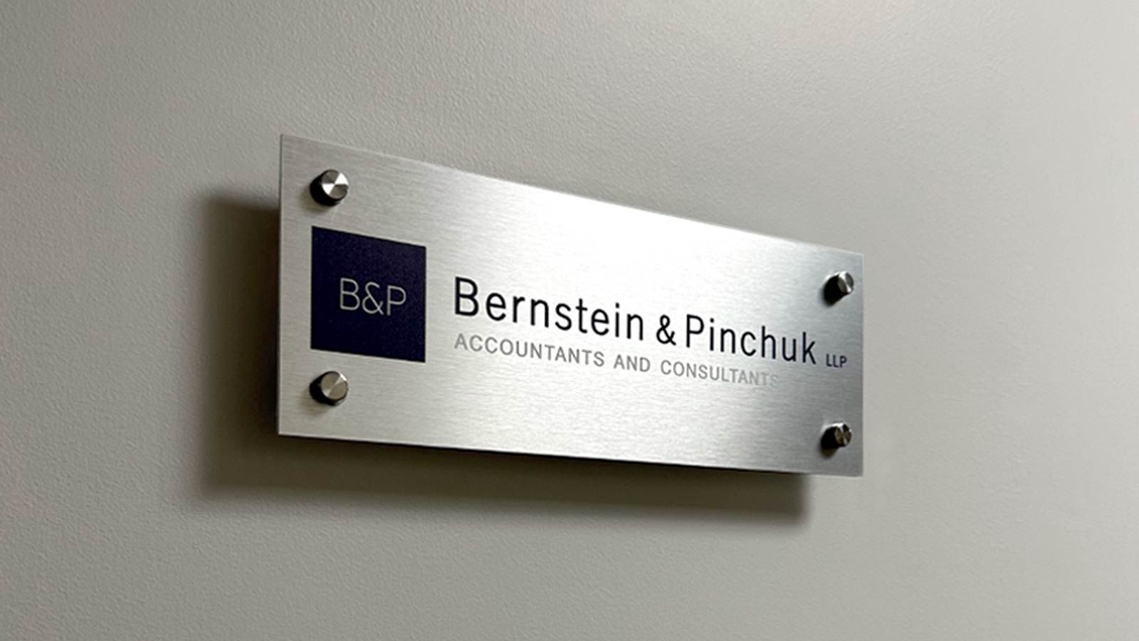 Bernstein and Pinchuk LLP aluminum sign attached to the wall
