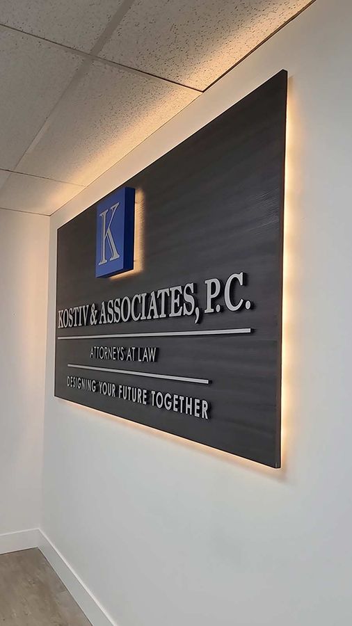 Kostiv & Associates, P.C. office sign mounted on the wall