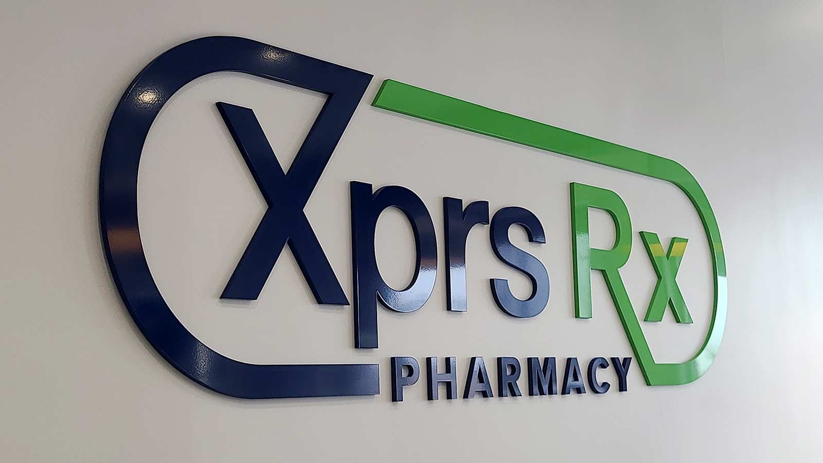 XPRS Rx Pharmacy logo sign attached to the wall