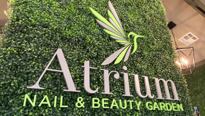 Atrium modern sign with decorative grass wall made of painted acrylic for salon branding