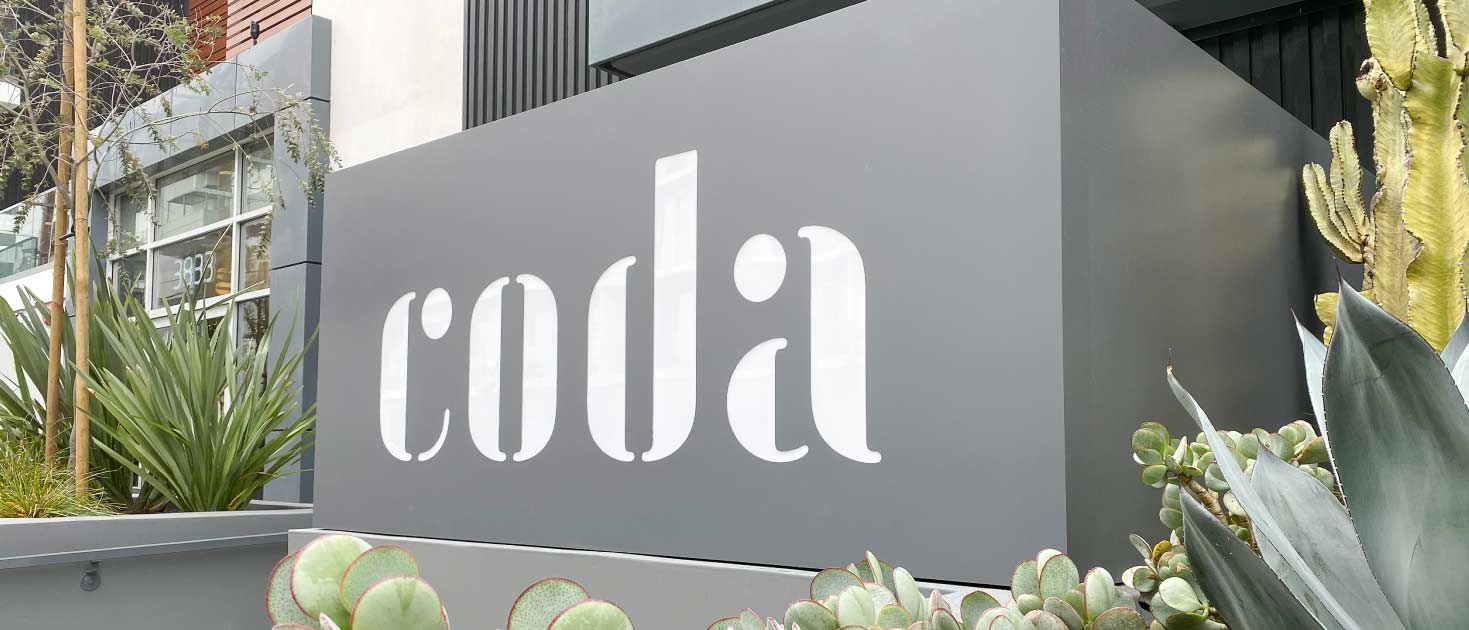 Coda modern sign in a free-standing style spelling the brand name made of aluminum and acrylic